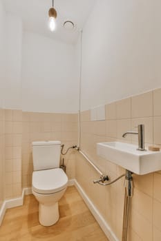 a bathroom with a toilet, sink and mirror on the wall next to it is a light fixture in the ceiling