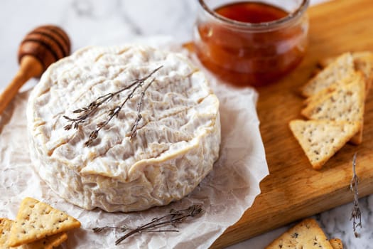 camembert soft french cheese served with liquid honey and crackers