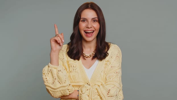 Eureka. Inspired pretty woman pointing finger up with open mouth, having good idea, plan, startup, showing inspiration motivation gesture, problem solution. Young girl isolated on gray background