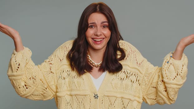 What Why. Sincere irritated woman raising hands in indignant expression asking reason of failure demonstrating disbelief irritation by trouble. Young confused pretty girl isolated on gray background