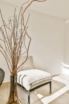 a living room with a tree in the corner and a white chair on the floor next to it, as well