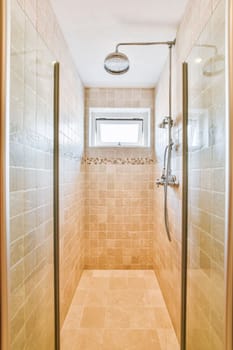 a walk in shower with tiled walls and beige tile on the floor, along with glass doors that allow access to the bathroom