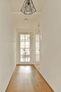 an empty room with white walls and wood flooring on either side, there is a light fixture in the ceiling