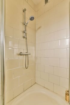 a bathroom with a bathtub, shower head and hand held in the corner of the tub is made out of glass