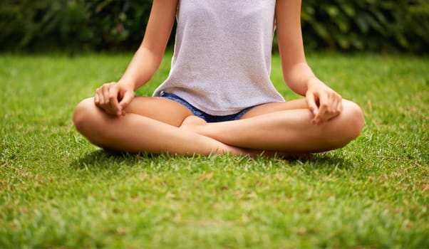 Finding her centre. a young woman meditating in the garden