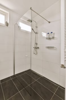 a modern bathroom with black tile flooring and white tiles on the walls, along with a walk - in shower