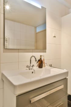 a bathroom with a sink and mirror on the wall next to it is an image of a bottle of beer