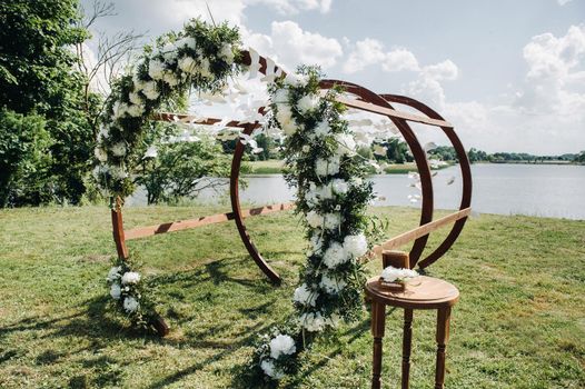 Wedding ceremony on the street on the green lawn.Decor with fresh flowers arches for the ceremony.