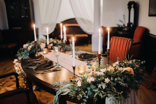 wedding table decoration with flowers on the table in the castle, table decor for dinner by candlelight.Dinner with candles.