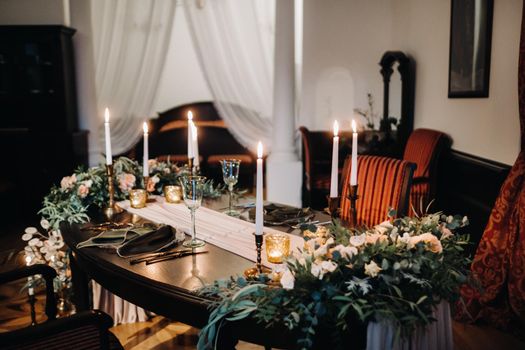 wedding table decoration with flowers on the table in the castle, table decor for dinner by candlelight.Dinner with candles.