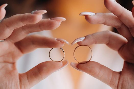 Close-up of two gold wedding rings in your hands.