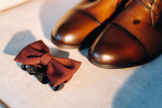 brown bow tie on a light background and boots