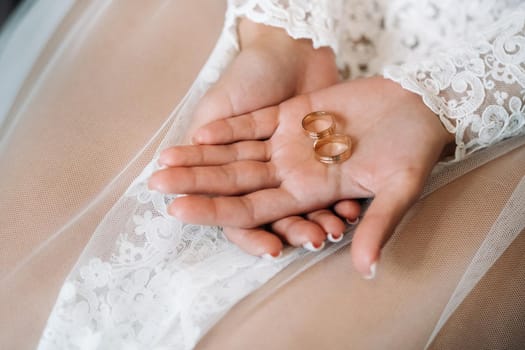 Close-up of two gold wedding rings in the palm of your hand.