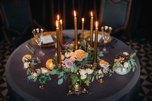 wedding table decoration with flowers on the table in the castle, table decor for dinner by candlelight.Dinner with candles.