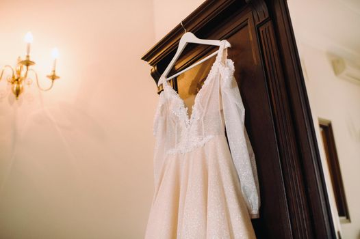 Vintage Wedding dress hanging on a wooden hanger.