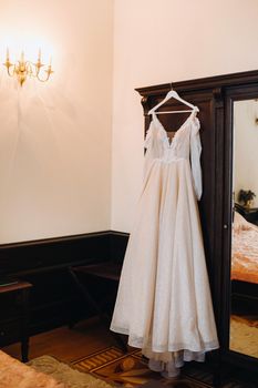 Vintage Wedding dress hanging on a wooden hanger.