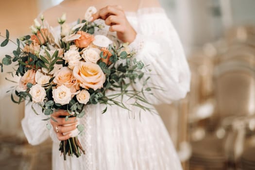 wedding bouquet with peonies in the hands of the bride under the veil.Morning of the bride.