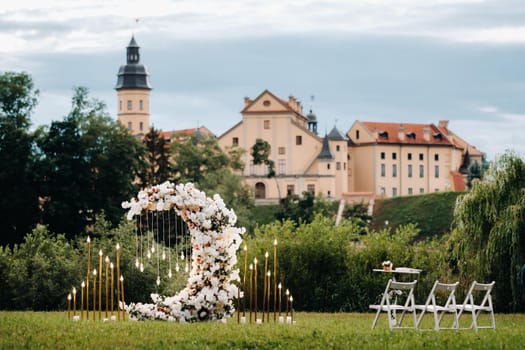 Wedding ceremony on b street near the Nesvizh castle.Decor with fresh flowers in the form of the moon