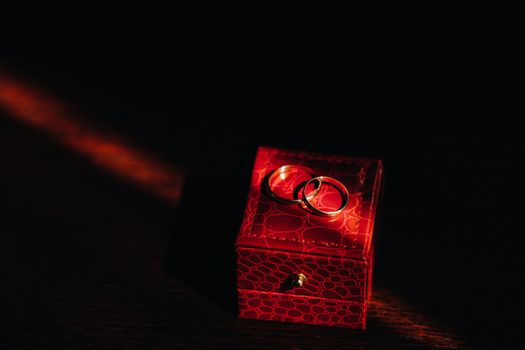 Close-up of two gold wedding rings for the wedding lie on a red box.