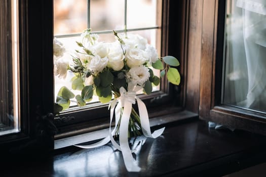 wedding bouquet with peonies and roses on a chair and boutonniere.The decor at the wedding.