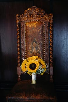 a wedding bouquet of sunflowers lies on an antique chair.Wedding Decor.