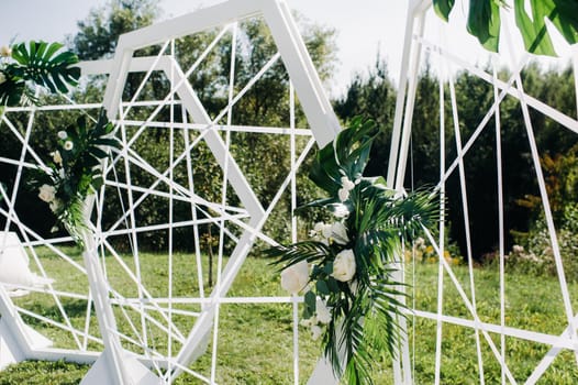 Wedding ceremony on the street on the green lawn.Decor with fresh flowers arches for the ceremony.