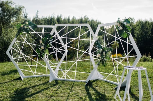 Wedding ceremony on the street on the green lawn.Decor with fresh flowers arches for the ceremony.