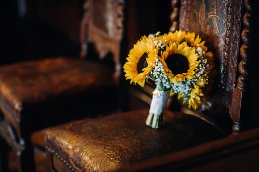 a wedding bouquet of sunflowers lies on an antique chair.Wedding Decor.