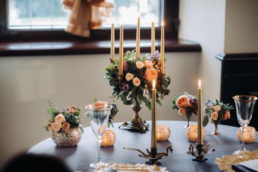 wedding table decoration with flowers on the table in the castle, table decor for dinner by candlelight.Dinner with candles.