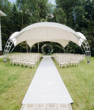 Wedding ceremony on the street on the green lawn.Decor with fresh flowers arches for the ceremony.