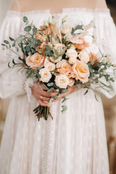 wedding bouquet with peonies in the hands of the bride under the veil.Morning of the bride.