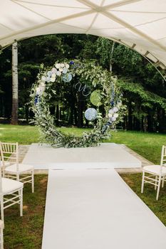 Wedding ceremony on the street on the green lawn.Decor with fresh flowers arches for the ceremony.