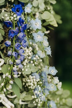 Wedding ceremony on the street on the green lawn.Decor with fresh flowers arches for the ceremony.