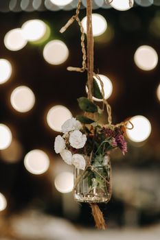 the wedding decor hangs near the candlelit dinner table.Dinner with candles.