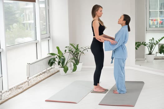 Caucasian woman stands on sadhu boards with therapist support