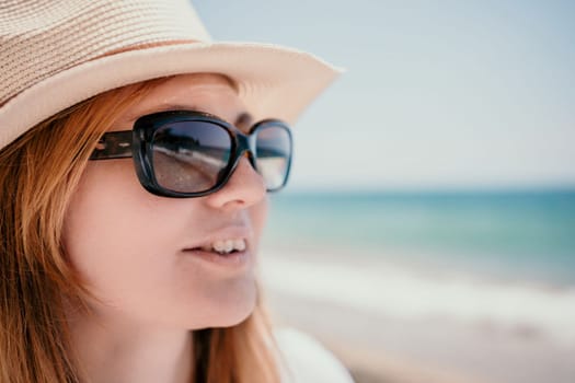 Young woman in red bikini on Beach. Blonde in sunglasses on pebble beach enjoying sun. Happy lady in one piece red swimsuit relaxing and sunbathing by turquoise sea ocean on hot summer day. Close up,