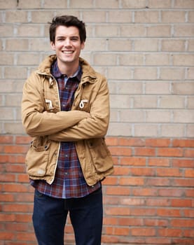 Welcome to my hood. a handsome young man standing outdoors with his arms crossed