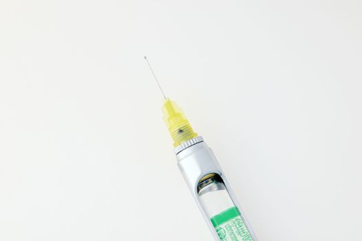 Steel dental syringe for local anesthesia, isolated on white. Carpool syringe for anesthesia in dentistry. Thin needle on a syringe for anesthesia in dentistry.