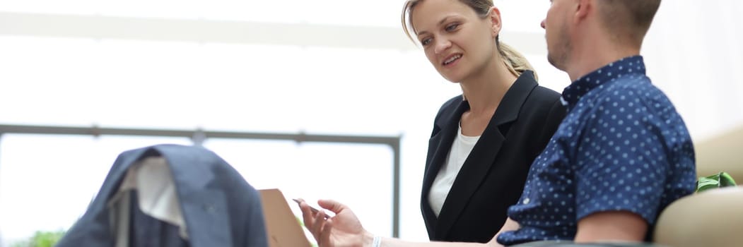 Young businessman is talking to secretary and asking to book tickets online for business trip. Business meeting at airport or hotel