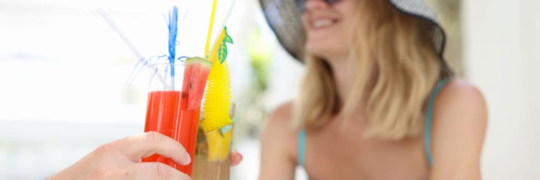 Happy couple in love toasting at resort in hotel. Summer refreshing cocktails concept