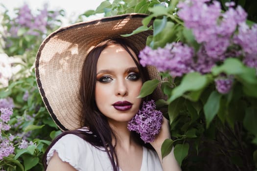 A fashionable girl with dark hair, a spring portrait in lilac tones in summer. Bright professional makeup