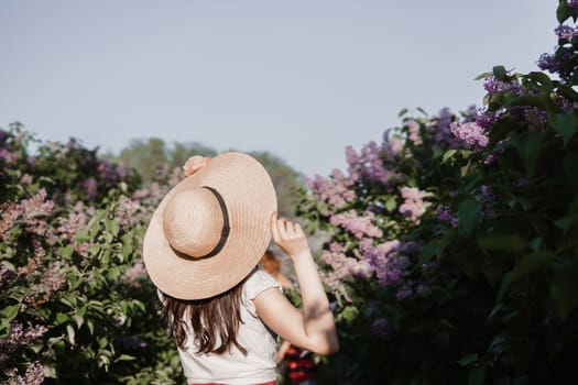 A fashionable girl with dark hair, a spring portrait in lilac tones in summer. Bright professional makeup. Rear view