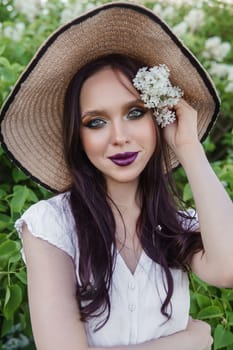 A fashionable girl with dark hair, a spring portrait in lilac tones in summer. Bright professional makeup