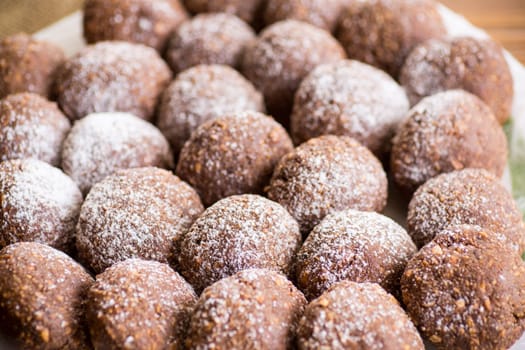 chocolate sweet cakes from mashed biscuits with additives, in a plate on a wooden table.