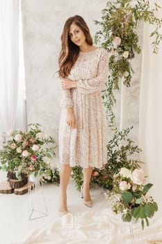 A brown-haired woman with long hair is having breakfast in a beautiful floral location. Spring portrait