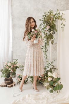 A brown-haired woman with long hair is having breakfast in a beautiful floral location. Spring portrait