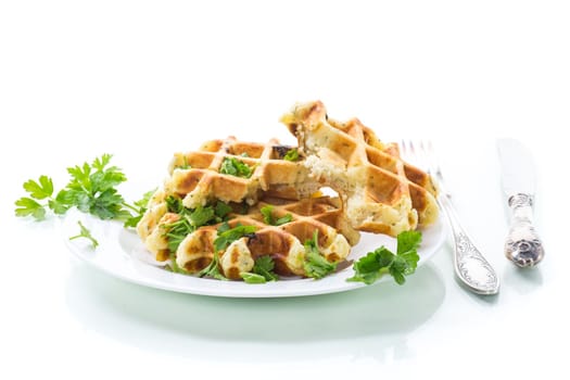fried Belgian vegetable waffles with spices and herbs, in a plate isolated on white background.