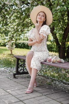 An attractive long-haired woman walks in the spring in the park of blooming apple trees. Spring portrait of a woman