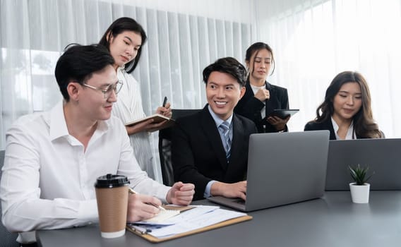 Harmony in office concept as business people analyzing dashboard paper together in workplace. Young colleagues give ideas at manager desk for discussion or strategy planning about project.