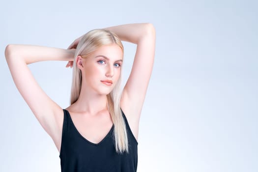 Personable woman lifting her armpit showing hairless hygiene underarm as beauty posing for cleanliness and perfect smooth skincare treatment in isolated background. Hair removal and epilation concept.